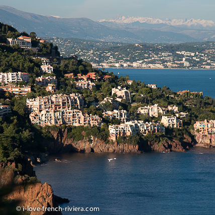 Les monts rouges de l'Estrel plongent directement dans la mer. Ici sur la route de la Corniche d'Or, de La Napoule  Saint-Raphael. Au fond du golfe, on distingue La Napoule et les Alpes enneiges